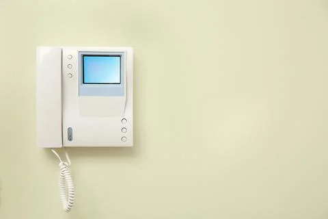 Modern intercom system with handset on light wall, space for text Stock Photos