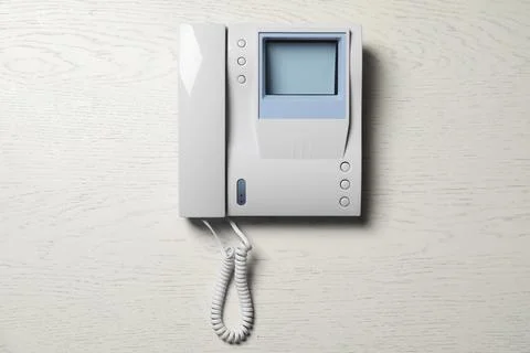 Modern intercom system with handset on white wooden background, top view Stock Photos