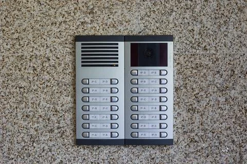 Modern intercom system with keypad and camera on granite wall Stock Photos