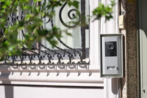 Modern intercom system near a decorative iron gate Stock Photos
