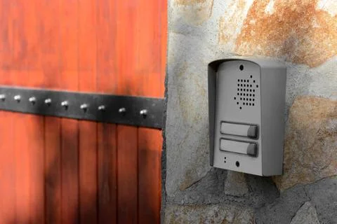 Modern intercom on textured wall with stone fragments outdoors Stock Photos