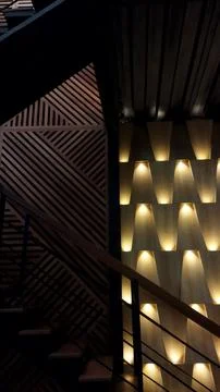 A modern interior design featuring a staircase and a geometric wall with warm Stock Photos