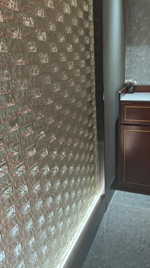 Modern interior design featuring textured golden wall paneling, illuminated by Stock Footage 336840532