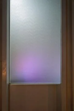 Modern interior design featuring translucent glass partition with ambient purple Stock Photos