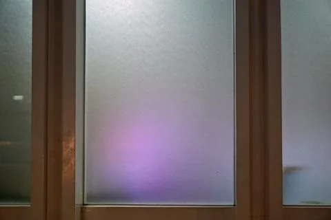 Modern interior design featuring translucent glass partition with ambient purple Stock Photos