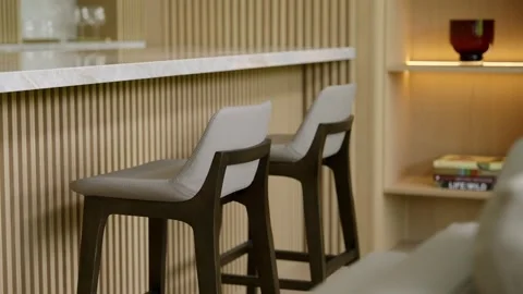 Modern interior space featuring two bar stools placed at counter. Counter with Video stock 297750799