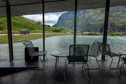 Modern interior space with seating area and large windows framing mountain va Foto stock