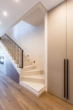 Modern interior staircase with white steps and black metal railing Fotos de archivo