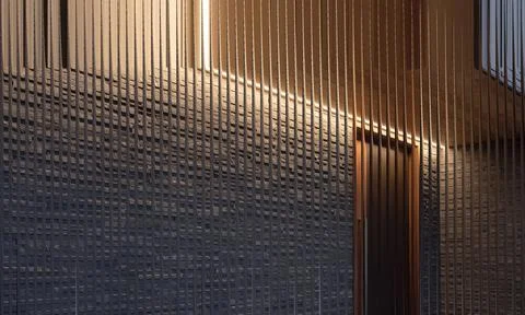 Modern interior stone wall and warm lighting viewed through fluted glass te.. Stock Photos