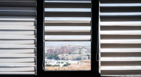 Modern Interior Window With Zebra Blinds and Soft Blurred City View Foto stock