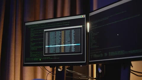Modern IT workspace with several monitors showing programming code. Stock Footage 323462595