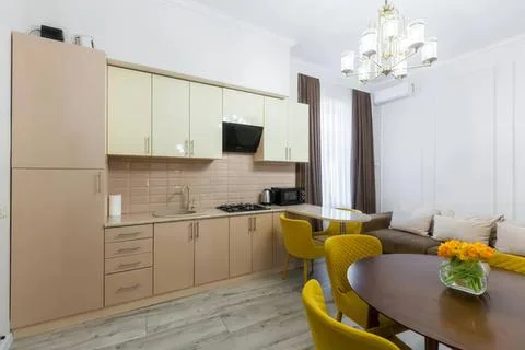 Modern kitchen and dining area with yellow chairs and sofa Stock-Fotos