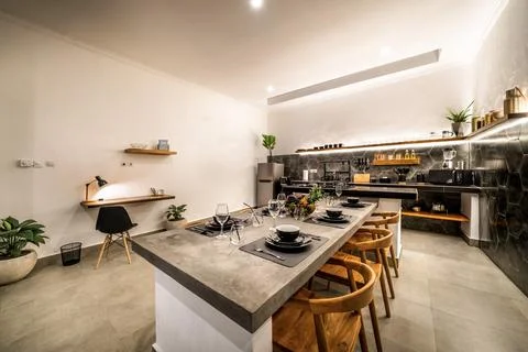 Modern kitchen with appliances. Subtle lighting. dining table made of polis.. Stock Photos
