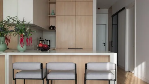 Modern kitchen with cabinet kitchen island chairs and hallway Stock Footage 302095561