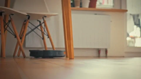 In modern kitchen compact robot vacuum cleaner glides across floor methodica Stock Footage 331866246