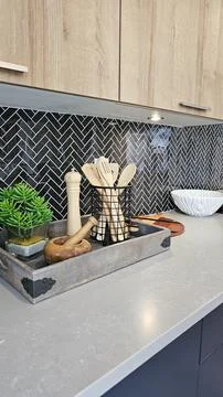 Modern kitchen countertop featuring stylish utensils in a decorative tray, with Stock Photos