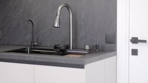 Modern kitchen design features sleek sink and stylish faucet in minimalist Stock Footage 310086525