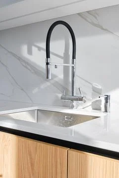 Modern kitchen design featuring a sleek faucet and elegant marble countertop Foto stock
