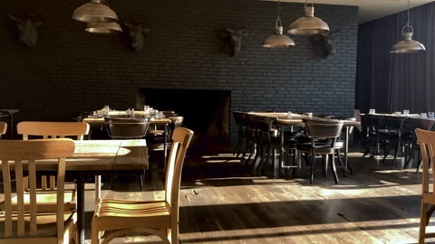 Modern kitchen dinner hall interior design. Wooden tables and black brick wall Vidéo 252033880