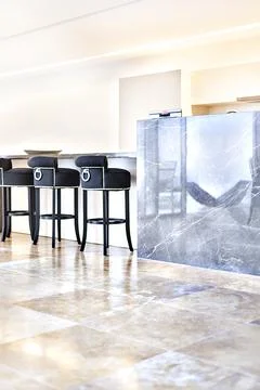 Modern kitchen floor area including black chairs and counter wall Stock Photos