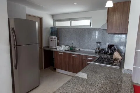 Modern kitchen with granite counters and wood cabinets view Stock Photos