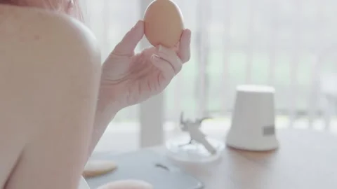 In a modern kitchen, a hand is reaching for brown eggs, highlighting elements of Stock Footage 288369660