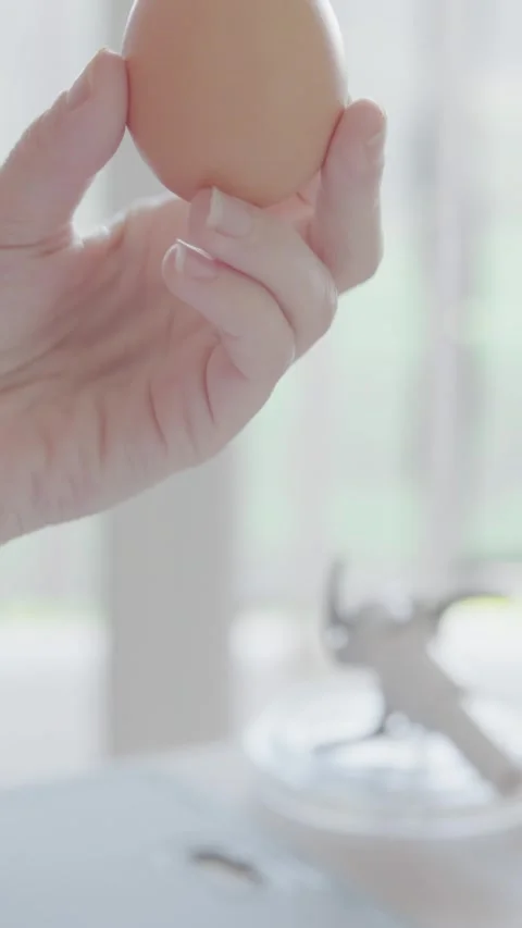 In a modern kitchen, a hand is reaching for brown eggs, highlighting elements of Stock-Footage 293207976