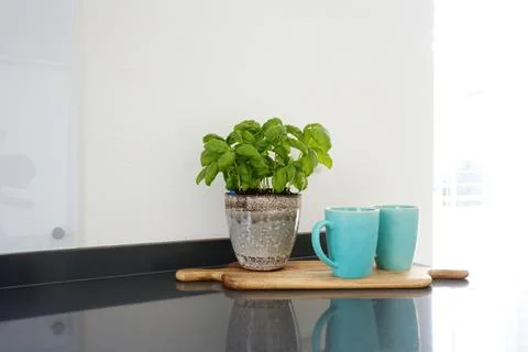 Modern kitchen interior with coffee cups and cutting board, clean white wall for Stock Photos