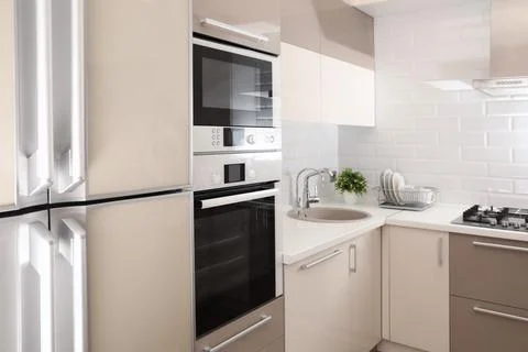 Modern kitchen interior with combination oven, microwave and fridge Foto stock
