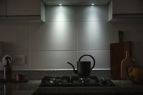 Modern kitchen interior with dark kettle on gas stove Foto stock