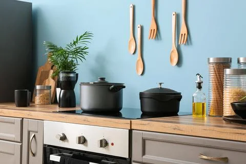 Modern kitchen interior design with cooking pots on induction hob and wooden  Stock Photos