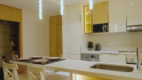 Modern Kitchen Interior with Dining Area and Warm Lighting Stock Footage 346043911