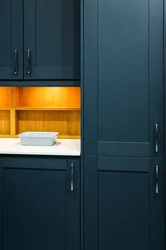 Modern kitchen interior featuring dark blue shaker style cabinets, wooden s.. Stock Photos