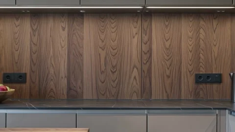 Modern kitchen interior featuring wooden cabinets, a stone countertop, and built 스톡 동영상 335786211