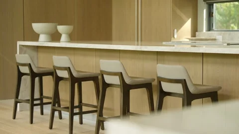 Modern kitchen interior with focus on kitchen island and four bar stools Video stock 297750853