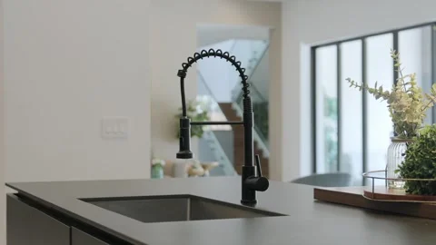 Modern kitchen interior. Focus on sleek, black faucet over sink that built into Stock Footage 282274038