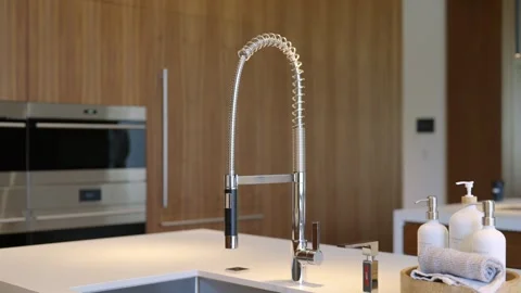 Modern kitchen interior with focus on stainless steel. Coiled high-arc faucet Stock-Footage 275825431