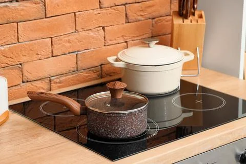 Modern kitchen interior with induction cooktop, saucepan, and dutch oven on a Stock Photos