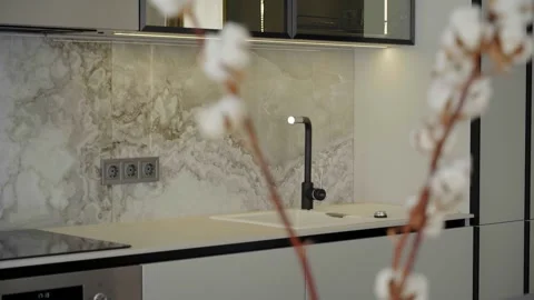 Modern kitchen interior with a marble backsplash and black faucet Vidéo 321300626
