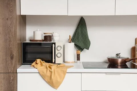 Modern kitchen interior with microwave oven, induction cooktop, and stylish a Stock Photos