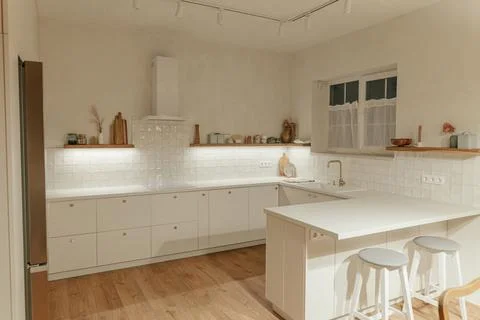 Modern kitchen interior. Stylish white kitchen cabinets with brass knobs, g.. Stock Photos