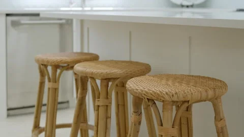 Modern kitchen interior with three wicker bar stools in front of white Stock Footage 275904700