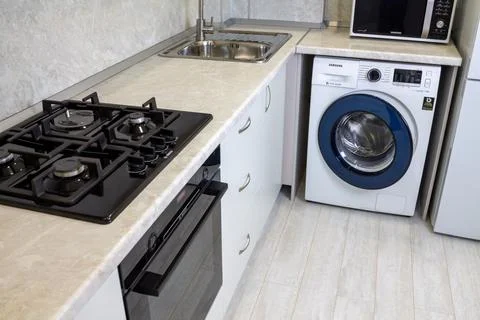 Modern kitchen interior. White kitchen cabinets, black gas hob and oven, washing Stock Photos