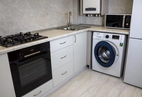 Modern kitchen interior. White kitchen cabinets, black gas hob and oven, washing Stock Photos