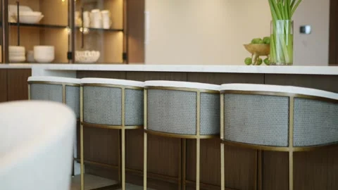 Modern kitchen or dining area with focus on row of stylish bar stools lined up Stock Footage 295551407