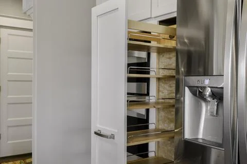 Modern Kitchen With Pull-Out Pantry Shelves And Stainless Steel Fridge. Stock Photos