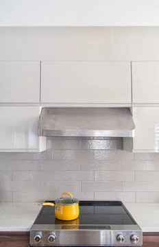 Modern kitchen range with yellow cooking pot on it Stock Photos