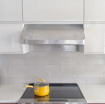 Modern kitchen range with yellow cooking pot on it Stock-Fotos