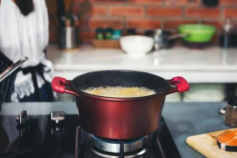 Modern kitchen with a red pot with boiling water Stockfoto's