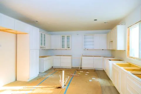 Modern kitchen renovation in progress with empty cabinets and flooring 库存照片
